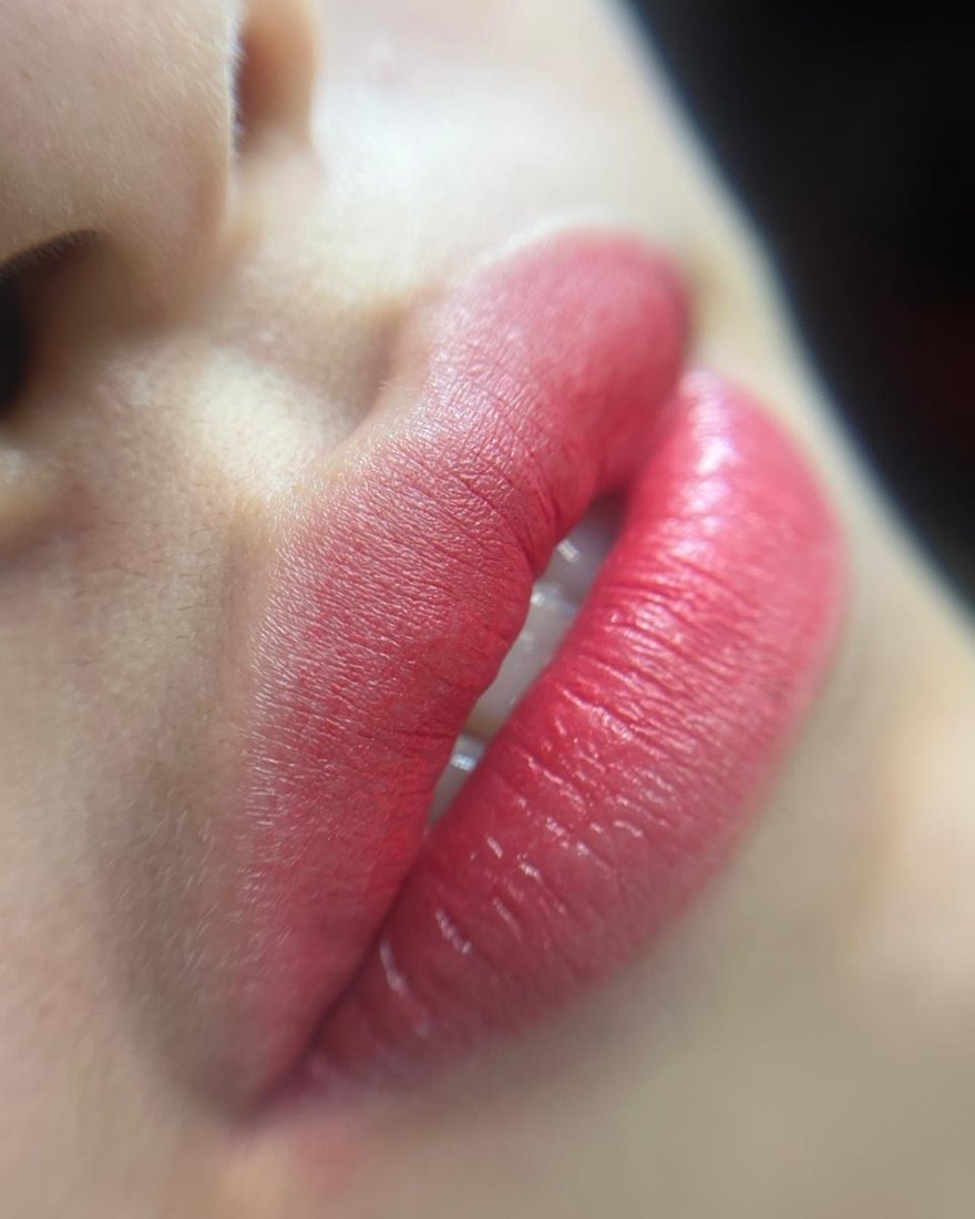 Lip blush being finished with gloss, close up